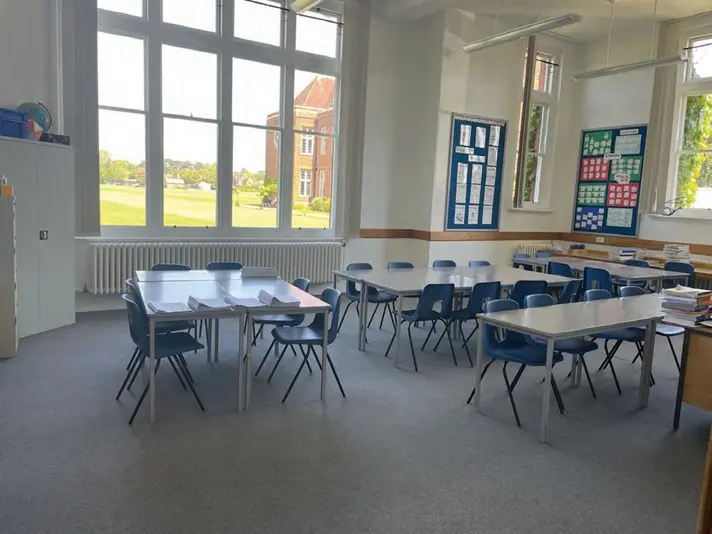 Salón de clases con ventanales hacia el campus